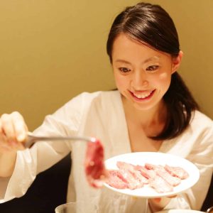 享用烤肉的年轻女性